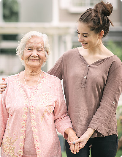caregiver and elderly woman smiling to each other